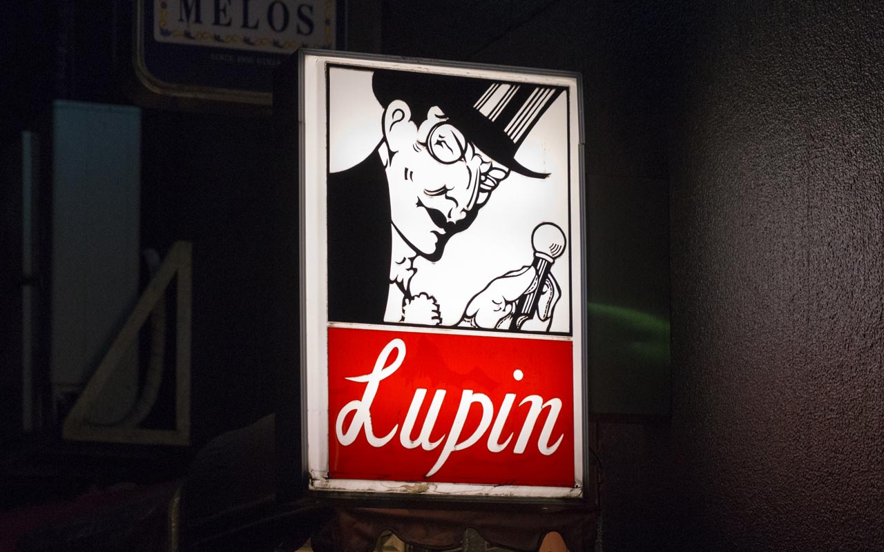 red and white sign for a bar called lupin